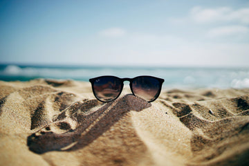 sunglasses on beach with intense sunglight
