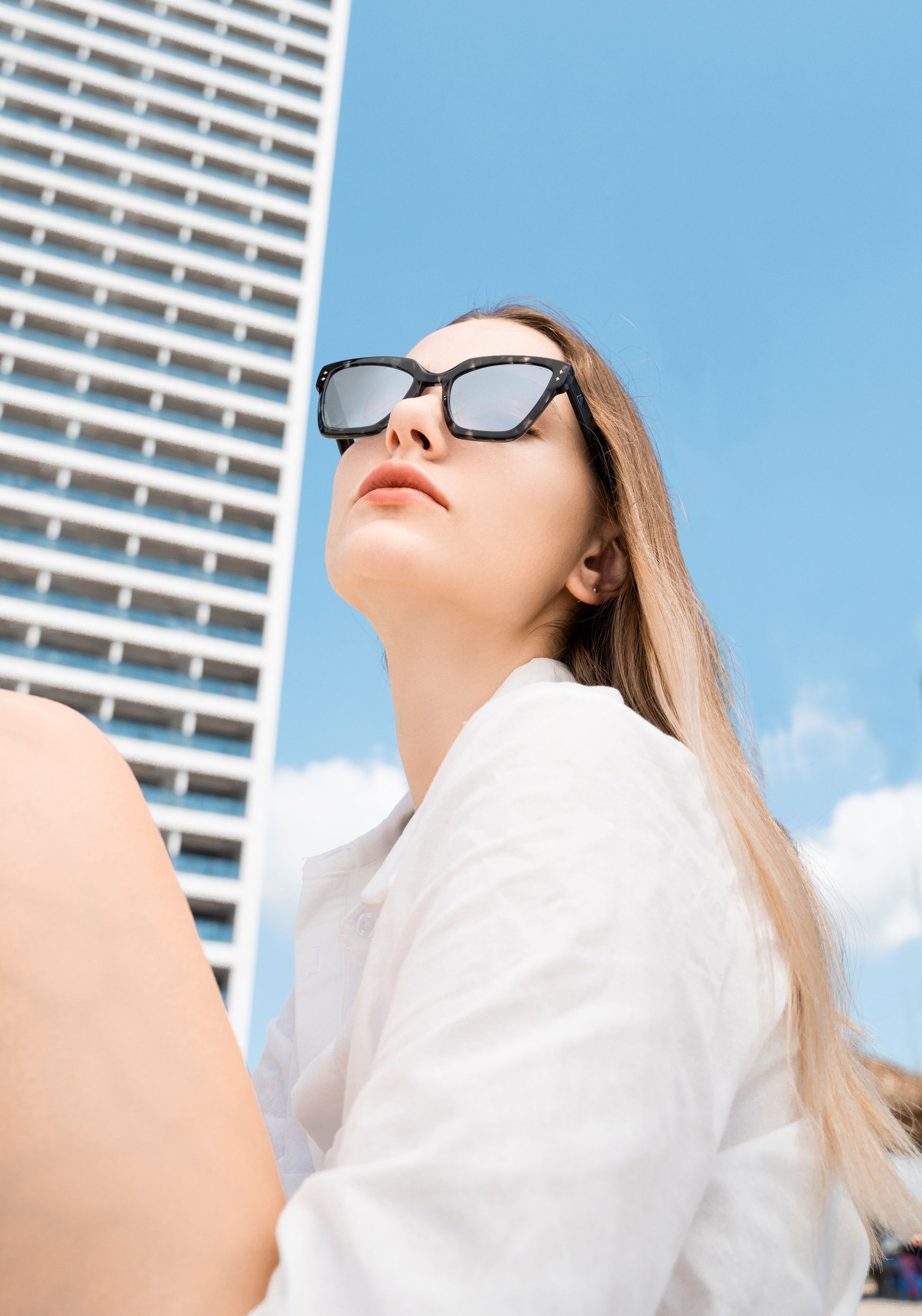 A woman in black and white checked sunglasses, square sunglasses
