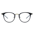 A pair of oval eyeglasses with a sleek frame design, featuring a blend of black and gold metal.