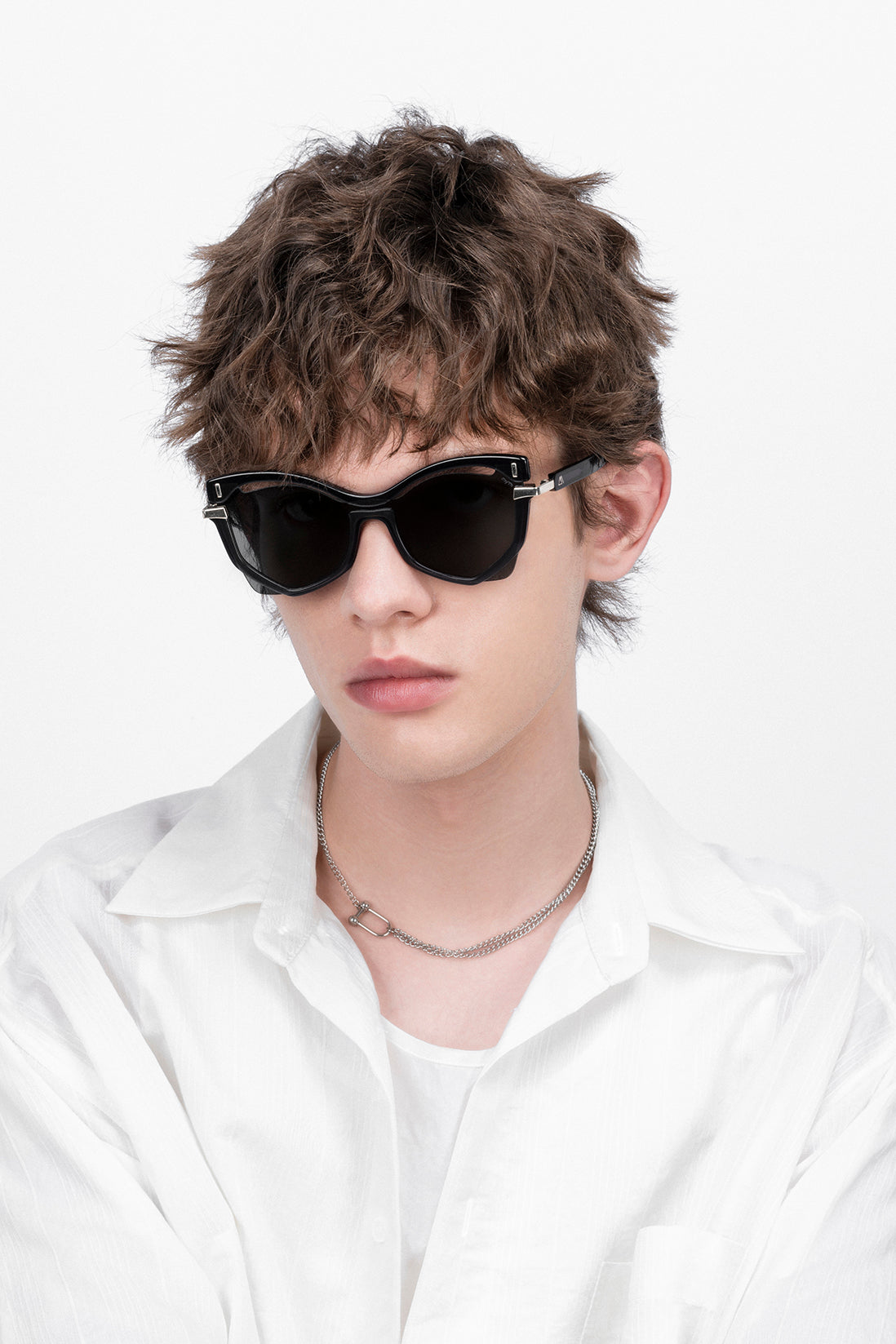 A pair of geometric sunglasses with a sleek design. The frames appear to be black with gold accents, and they have dark lenses.