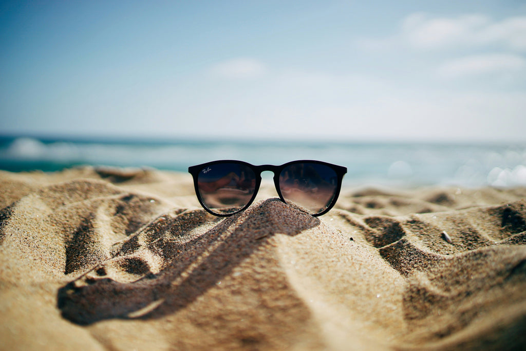 sunglasses on beach with intense sunglight