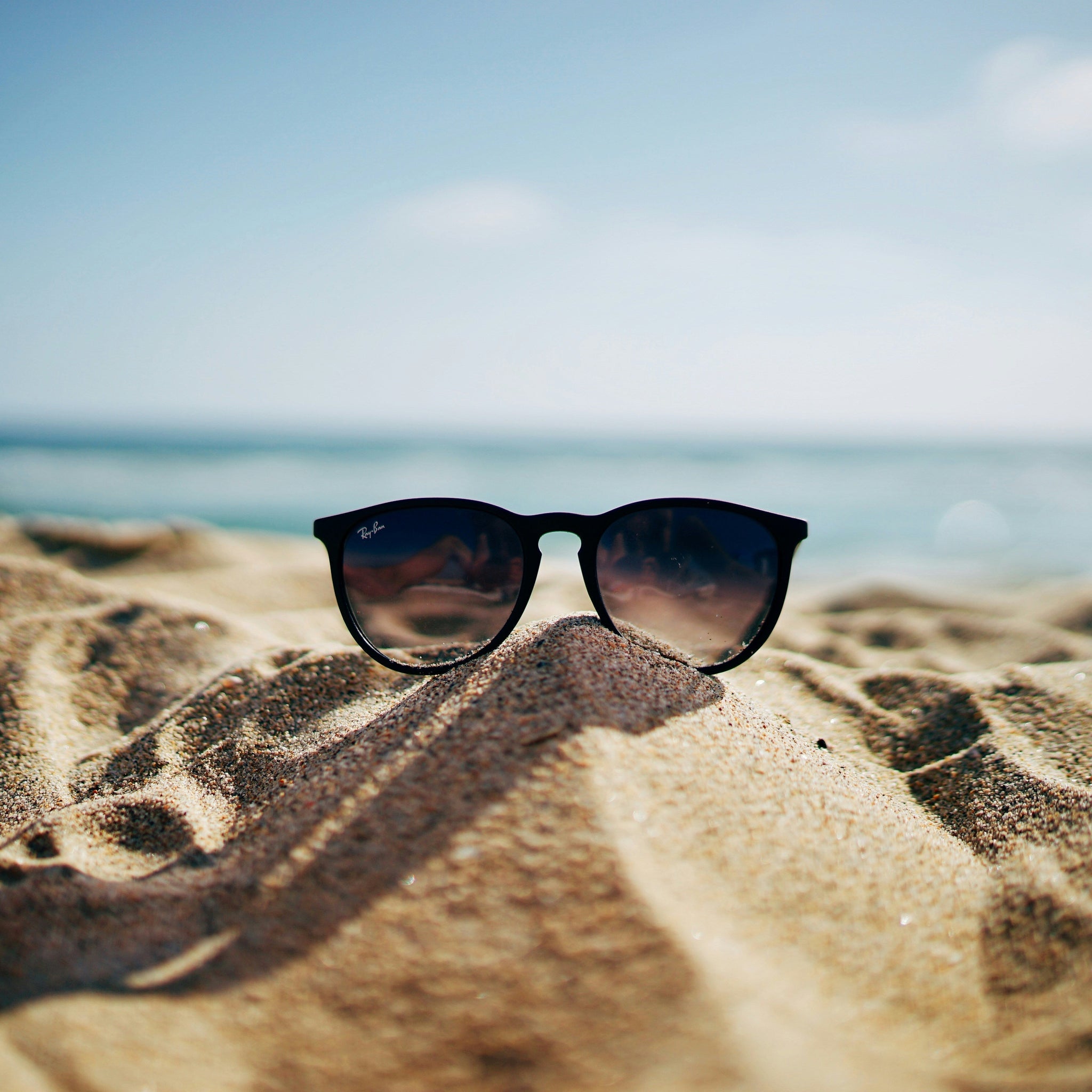 sunglasses on beach with intense sunglight