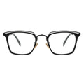 A pair of rectangular eyeglasses with a browline design, featuring a black frame with gold accents on the hinges and transparent lenses.